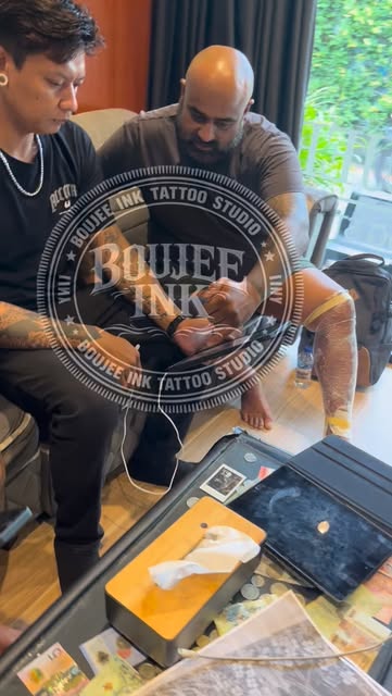 Artists at The Boujee Ink working on a client in the studio