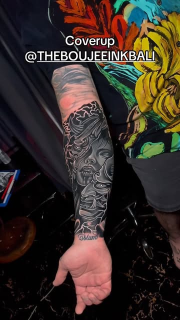 Black and grey forearm sleeve covering an older tattoo