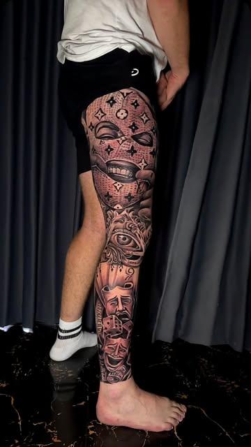 Full leg sleeve in black and grey featuring faces and patterns